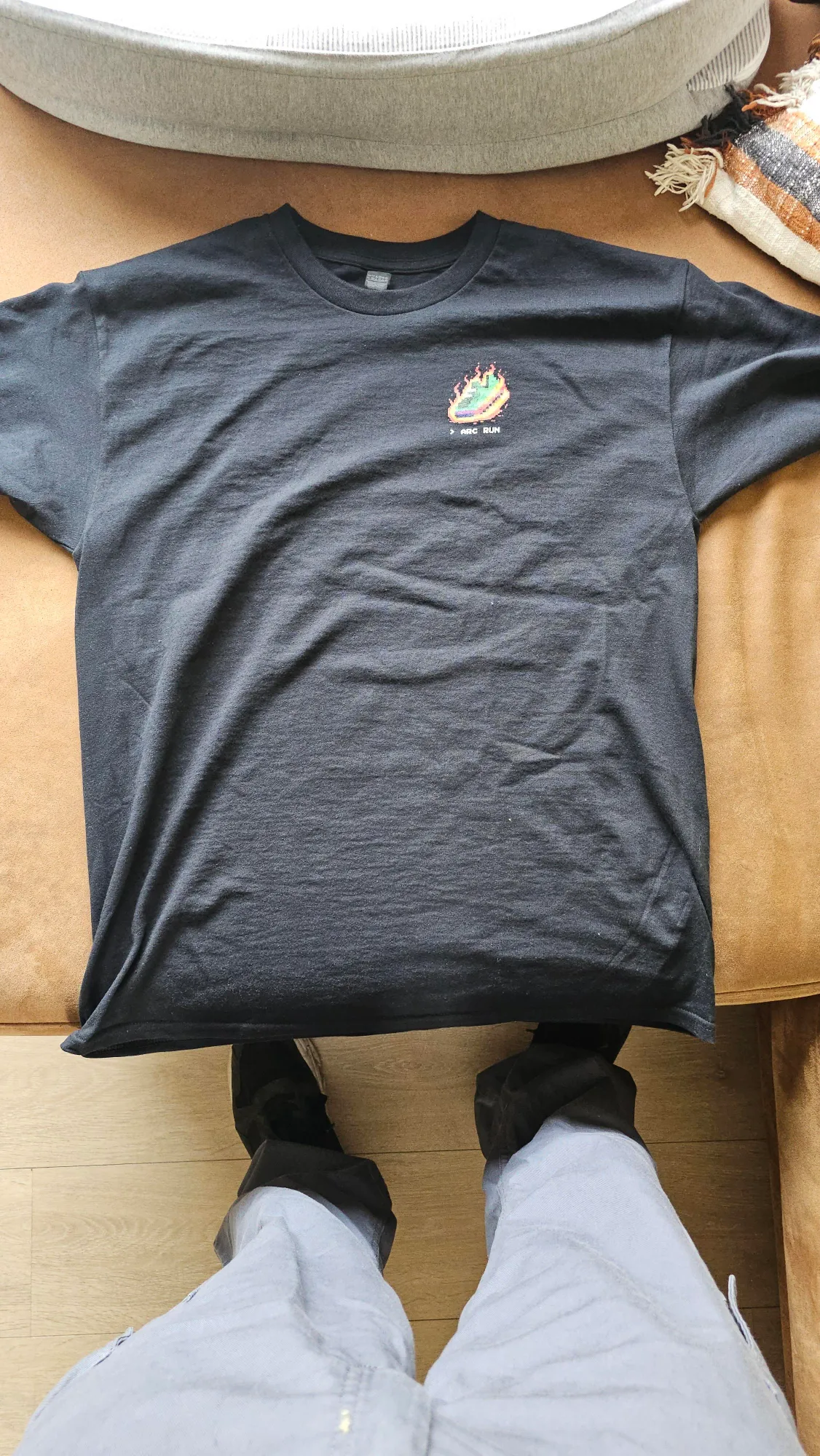 Uma t-shirt preta do Arc Run estendida, com o ténis pixel em chamas no peito